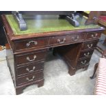 Reproduction mahogany kneehole pedestal desk with leather inset top.
