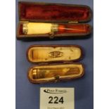 Two cased cheroot holders, one with 9ct gold collar, the other with silver collar.