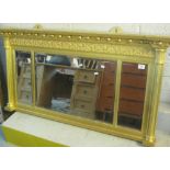 Heavily gilded three section, bevel plate, relief foliate over mantel mirror.