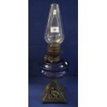 Early 20th Century double burner oil lamp with blue glass reservoir and cast metal pierced base,