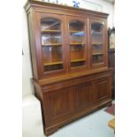 Large modern hardwood two stage display cabinet on bracket feet.