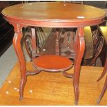 Edwardian mahogany oval two tier occasional table on casters.