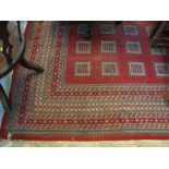 Large Middle Eastern design carpet with geometric borders on a red ground with square geometric