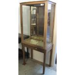 20th Century single door, glazed display cabinet on stand.