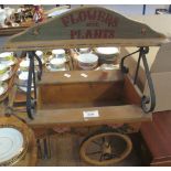 Novelty wooden and metal planter in the form of a miniature cart, labelled: 'Flowers and plants'.