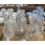 Tray of various cut and moulded glass decanters with stoppers, two with 'sherry' and 'port' labels.