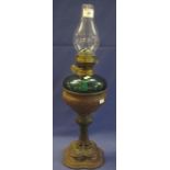 Brass double burner oil lamp with coloured glass reservoir on a cast metal base with clear chimney.