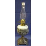 Brass double burner oil lamp with ceramic reservoir set on a cast metal base with clear chimney. (B.