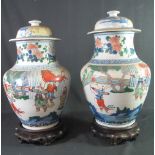 TWO SIMILAR CHINESE PORCELAIN, BALUSTER SHAPED, LIDDED VASES in transitional Wucai style.