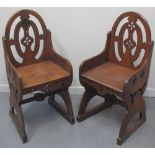 PAIR OF VICTORIAN GOTHIC DESIGN OAK SIDE CHAIRS with oval pierced backs, low arms and solid seats on