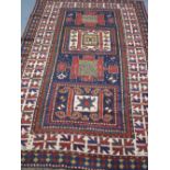 KARATCHOF KAZAK GEOMETRIC RUG decorated with panels on dark blue ground within a geometric, multi-