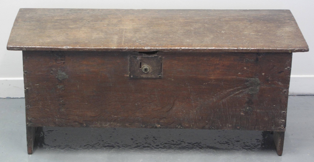 17TH CENTURY PRIMITIVE OAK PLANK CHEST OR COFFER having a hinged top, standing on end supports.