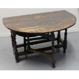 LATE 17TH CENTURY STAINED OAK GATE LEGGED TABLE on baluster turned legs and standing on bun feet,