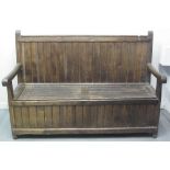 EARLY 20TH CENTURY STAINED PINE SETTLE having vertically boarded back above two lift seats to the