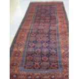 PERSIAN BELUCH GEOMETRICALLY DECORATED RUG with flower head design dark blue ground field within a