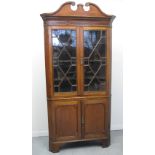 EARLY 19TH CENTURY WELSH OAK TWO STAGE CORNER CABINET, having broken swan neck pediment over a