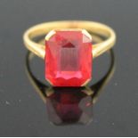 18CT GOLD AND SYNTHETIC RUBY RING. The step cut stone in claw mount. Ring size K & 1/2. French