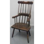 PRIMITIVE WELSH COMB BACKED FIRESIDE ARMCHAIR with shaped cresting over scrolled arms on a solid