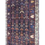 SMALL WEST PERSIAN KURDISH JAF RUG overall with flower head medallions on a dark blue ground