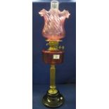 Early 20th Century brass double burner oil lamp with cranberry glass reservoir on a brass pedestal