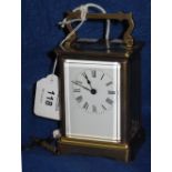 French brass carriage clock with full depth enamel Roman numeral dial and swing handle, with key.