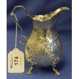 Silver repousse scroll decorated cream jug raised on four hoof and shell design feet, London, 1900,