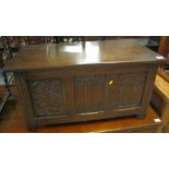 Reproduction oak blanket box or coffer, having three carved panels on stile feet. (B.P. 24% incl.