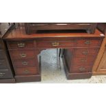 Edwardian mahogany kneehole desk having four drawers to each pedestal, on a platform base. (B.P.