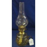 Small brass single burner chamber oil lamp with moulded coloured glass reservoir and clear chimney.