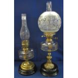 Two early century brass double burner oil lamps with glass reservoirs on brass pedestals with