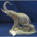 Lladro porcelain study of a trumpeting African elephant and calf on naturalistic base.