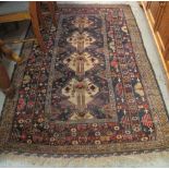 Middle Eastern geometric design rug with various motifs on a dark blue ground within a multiple