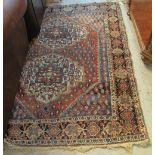 Middle Eastern red ground foliate design rug with lateral motifs to the red field within a multiple