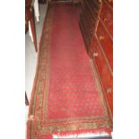 Turkish red ground runner with flower head field and banded border, 340 x 96cm. (B.P. 24% incl.