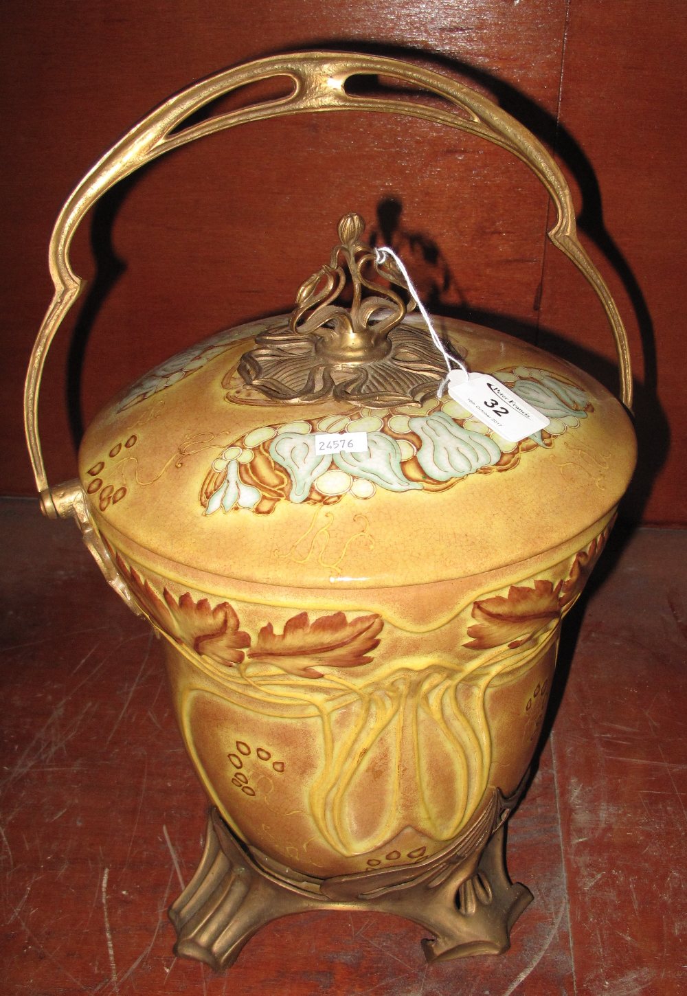 Art Nouveau style swing handled pot and cover on gilt metal base,