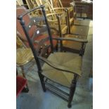 Stained elm ladder back armchair on rush seat. (B.P. 24% incl.