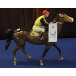 Beswick china racehorse and jockey, the jockey in yellow and black colours with red cap,