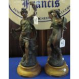 Pair of reproduction spelter figures on circular wooden bases, marked: 'Apollon, Bruchon and Phebe'.