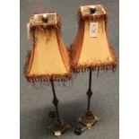 Pair of tall classically styled table lamps with ceramic balusters and tasseled fabric shades.