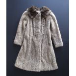 A full length, silvery light brown mink coat, double breasted with buttons and hook fastenings, silk