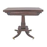 An English Victorian mahogany folding cards table on a central column on four splay legs on brass