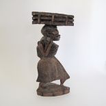 An African hardwood carving of a woman carrying a basket on her head, H36cm.