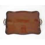An English early 20th century mahogany oblong serpentine tray with brass and wood handles. 60X39cm