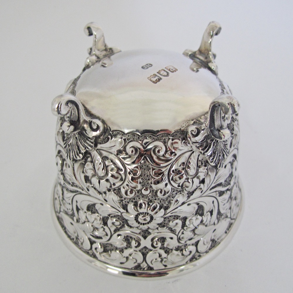 A sterling silver cup decorated with engraved and repousse flowers on four feet, by Sibray, Hall & - Image 3 of 5