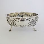 A sterling silver rose bowl on three feet with repousse and engraved flower decoration, hallmarked