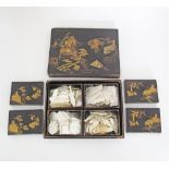 A Japanese lacquer box containing four smaller boxes with a quantity of mother of pearl engraved