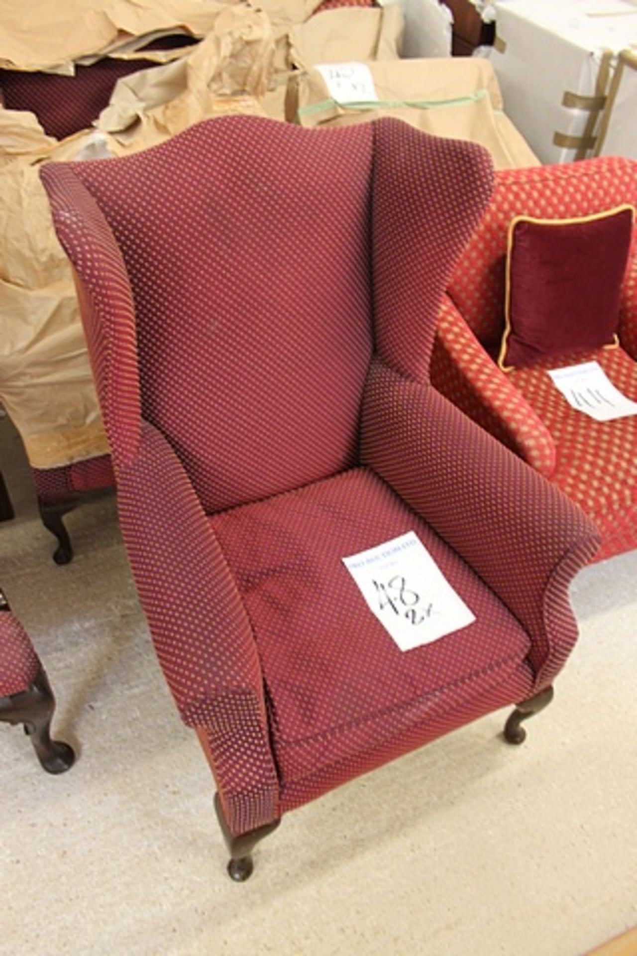 A pair of wing back burgundy with gold repeating pattern arm chairs loose seat pad cushion on