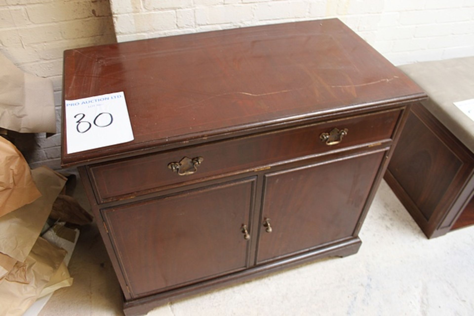 Mahogany two door cabinet on plinth base panelled doors below a drop down drawer internally fitted