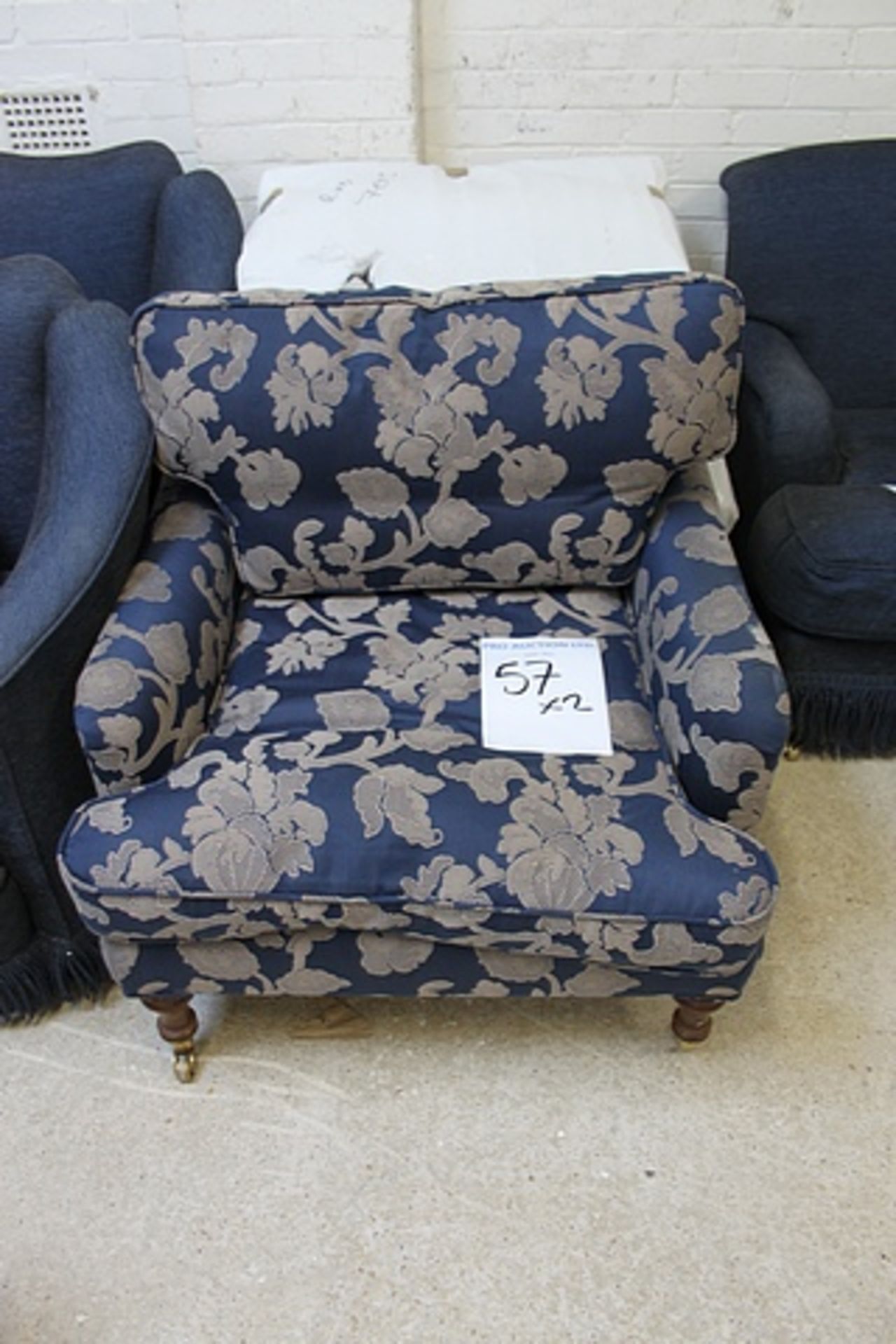 A pair of upholstered blue with repeating floral gold pattern front castors soft cushions 560mm x