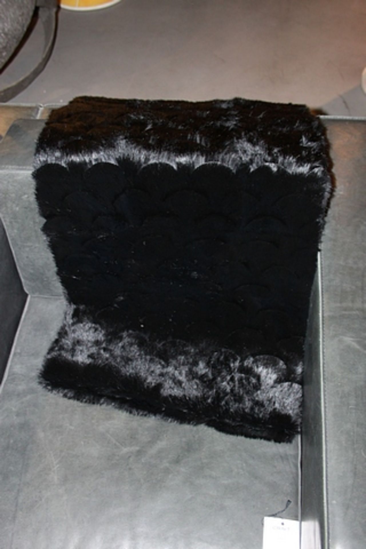 Throw Conejo is a luxuriously soft black rabbit fur soft furnishing accessory with scallop style,